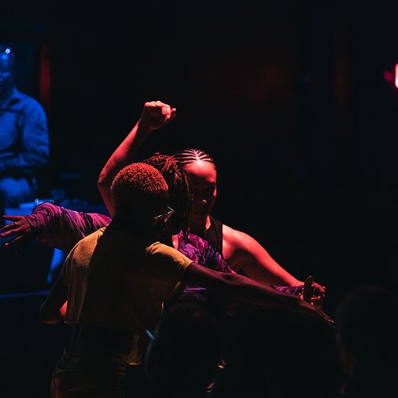 Three Black bodies of different colors intertwined in movement and gestures.