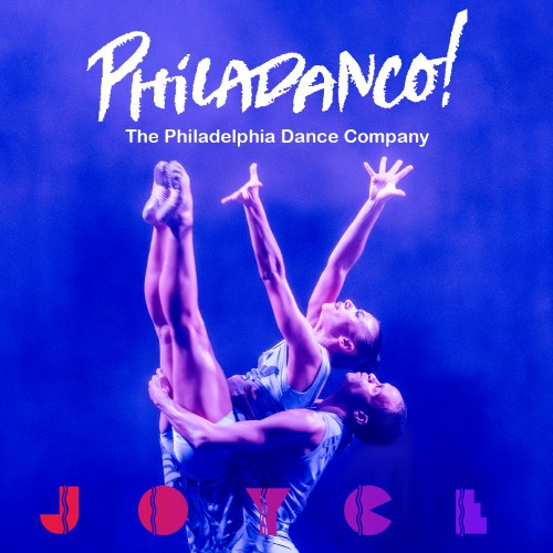 A dancer, lifted by another dancer, reaches towards the sky with her hands and feet extended.