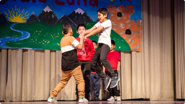 Three young male dancers moving on stage together