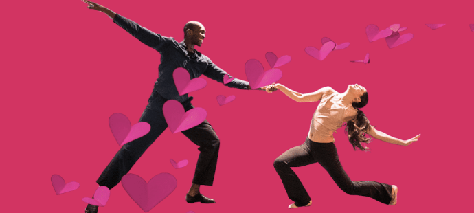 Two dancers holding hands with a pink background