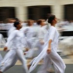 Intentionally blurred image of many dancers in white tops & leggings running