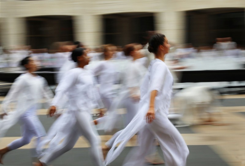 Intentionally blurred image of many dancers in white tops & leggings running