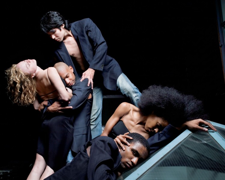 1 dancer leaping and 2 standing facing front with heads turned towards the dancer who is leaping   