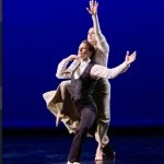 Duet: Male in black with white shirt; female lifted on partner's back