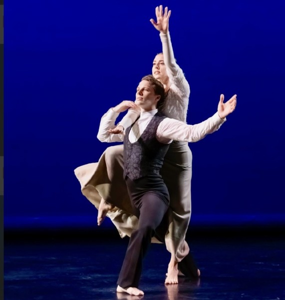 Duet: Male in black with white shirt; female lifted on partner's back