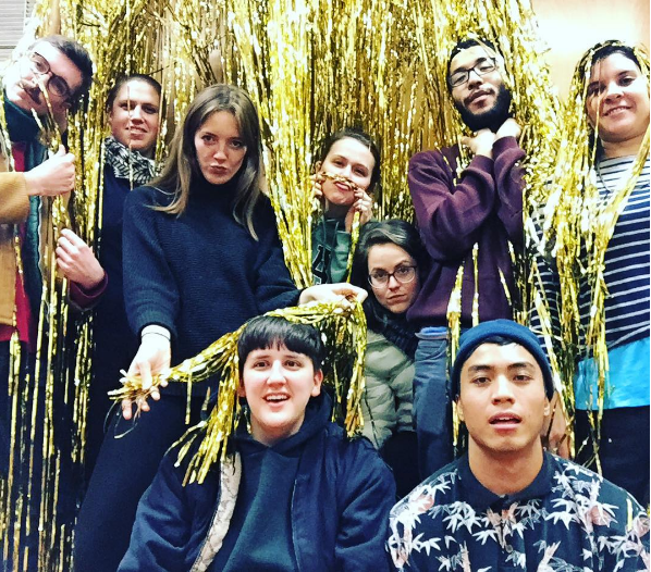 group of 9 interns in a cloud of gold fringe 