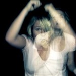 Image of two photos of a person wearing a white t-shirt, overlayed on top of one another so they blur together slightly.