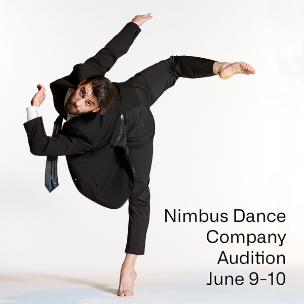  A male dancer in a suit and tie performs a pitch turn in back attitude.