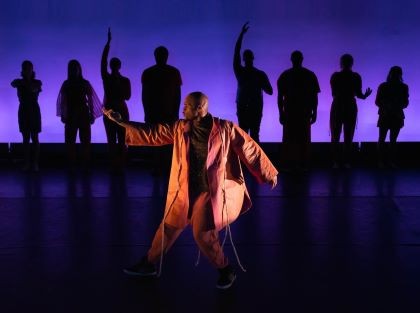 A photo of a Brooklyn Ballet member in all brown dancing. 