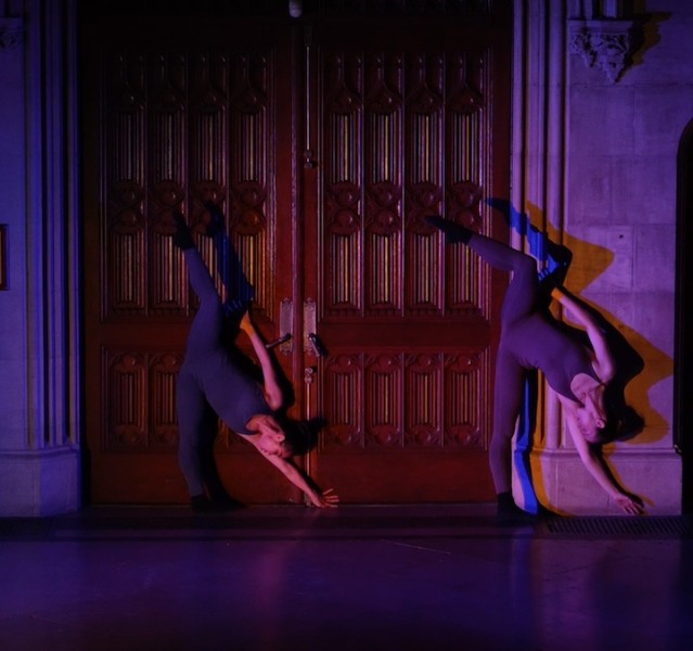 2 dancers upside down again a door. 