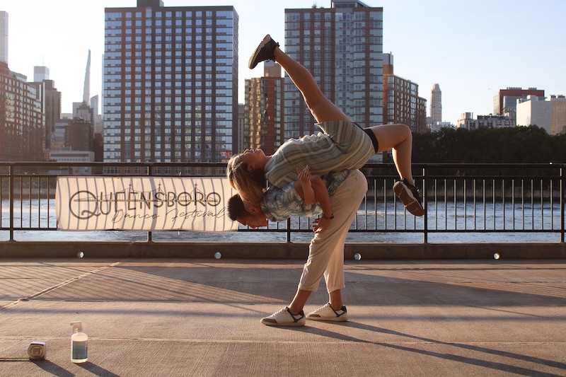 Male dancer lifting female dancer on his back, female dancer facing sky