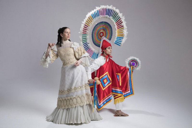 Two dancers pose in traditional period costumes from the Puebla region of Mexico