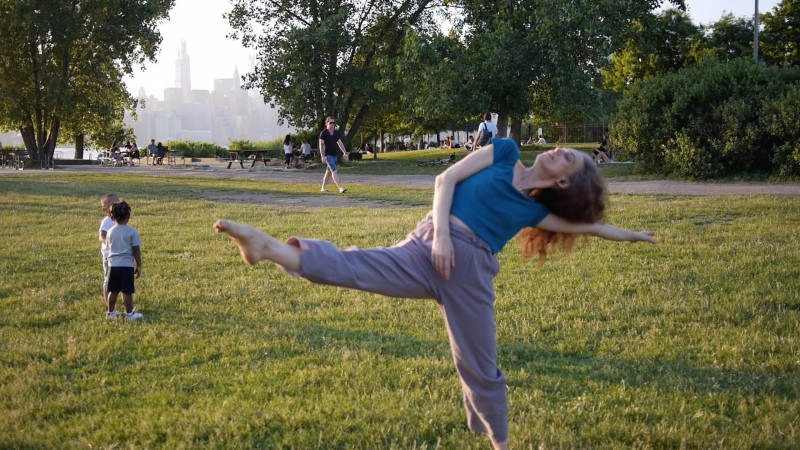 dancer reaching out, in nature, children nearby