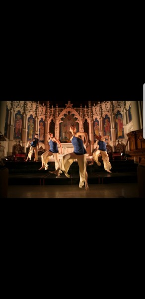 5 dancers inside church kicking in unison, smiling