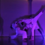 Three Dancers Pose in Dark Purple Lighting