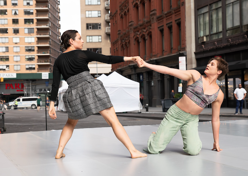 Two dancers holding hands leaning away from each other
