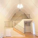 A large, open space with a double staircase in the background.