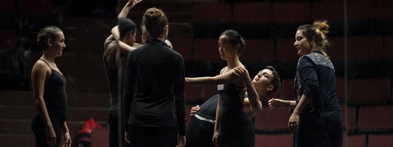 A group of dancers onstage in a rehearsal