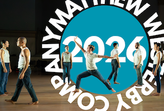 One dancer in a lunge is surrounded by others, dancing on a wooden floor.