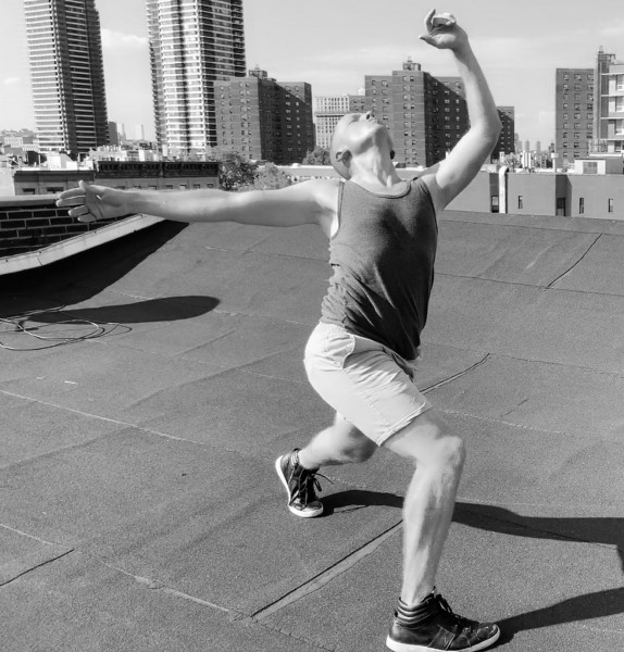 Man dancing on roof in bright sunlight.