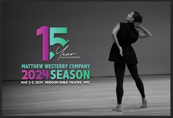 A single dancer stands with her back to the camera in a striking gestural freeze.