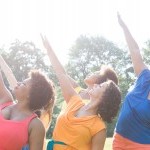 Dancers dressed in bright colors reach toward the summer sun.