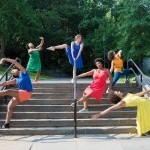 Six women pose on a staircase in a park. 