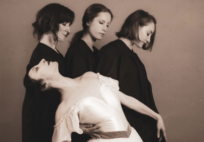ballerina Franceska Mann is supported by her dancers in sepia hued photo