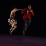 A swing dance couple jumping