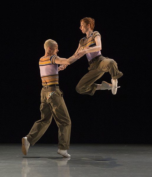 A jazz dance duet with one of the dancers in a partnered jump.