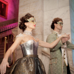 Two venetian dancers perform a partner dance in gold baroque costumes.