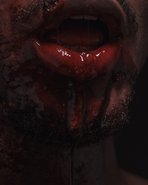 Close-up image of a person’s mouth with blood and saliva pouring down their chin.