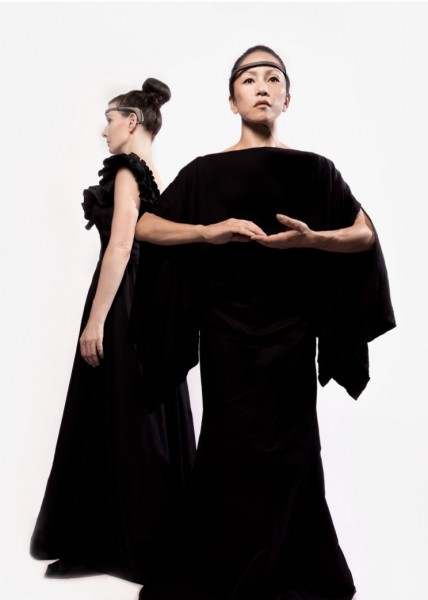 Two dancers wearing long black dresses and a MUSE 2 brain recording headband. One dancer is profile, and the other facing front.