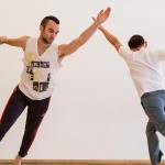 three people mid-motion dancing in a studio.