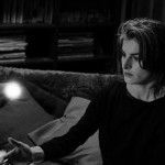 Woman sitting with hand outstretched under a floating ball of light