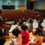 Students Sit Around African Dance Teaching Artist with Drum