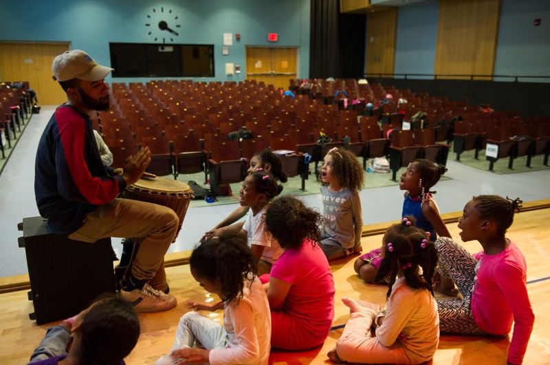 Students Sit Around African Dance Teaching Artist with Drum