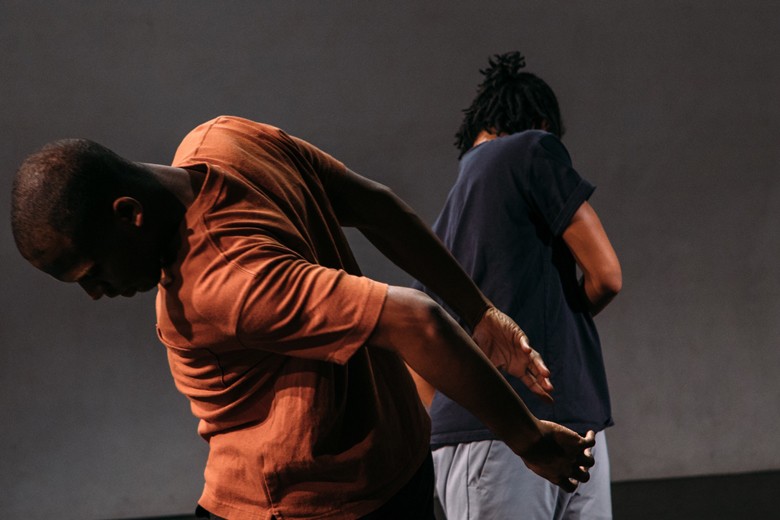 Two dancers dance with their backs to the camera.