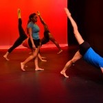 An African American woman walking in between three artists of color in three legged dog.