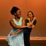 An African American woman crosses in front of an Asian American man