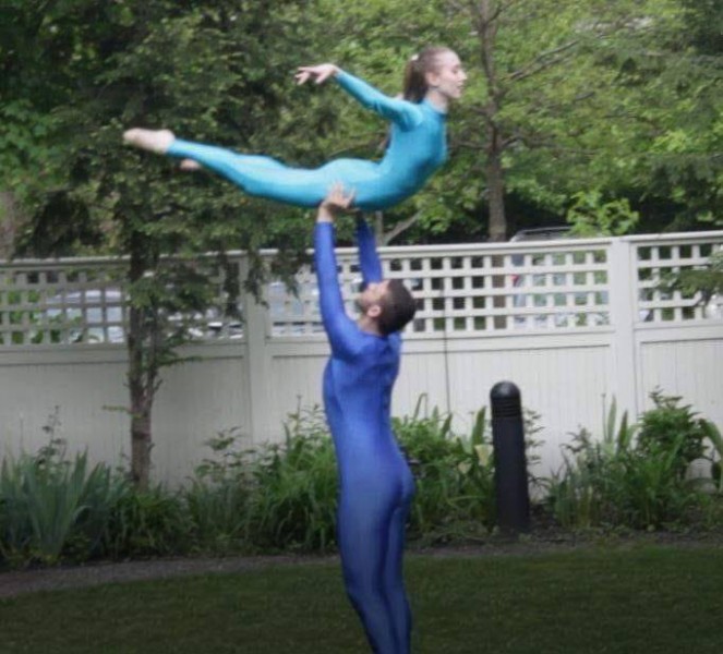 Hanna Q Dance Company, Male Dancers lifting female dancer over his shoulder. Dressed in white. 