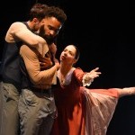 Dancers in an emotional gesture. Two male identifying dancers hold each other as a woman reaches to them. They look away.