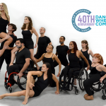 A group standing and seated dancers are arranged in likeness of a mountain slope against a white background with a logo above.