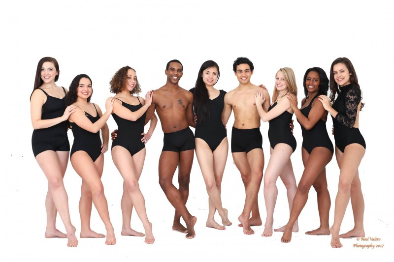 Dancers in a line, holding arms and smiling