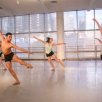 Several dancers moving in a studio setting
