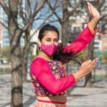 Minila is dancing in a pink dance outfit with a matching pink mask