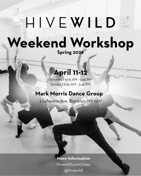 Black and white image, 8 dancers in a clump lunging with their arms up and backs facing the camera