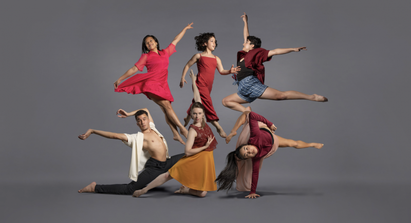 Six dancers with color outfits against a plain grey background