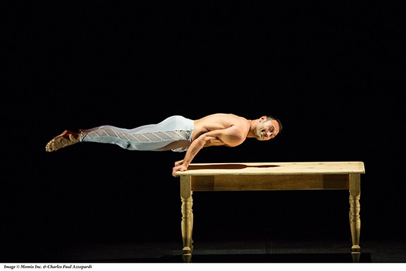 In the dance "Table Talk" a dancer has placed his hands on the edge of a table and then lifted his entire body.