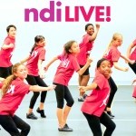 Children dancing in a studio. In bold bright purple letters it says ndiLIVE!